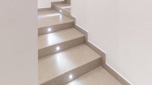 A staircase with a handrail, leading to a landing. - Nimbus Rooms (Naples)