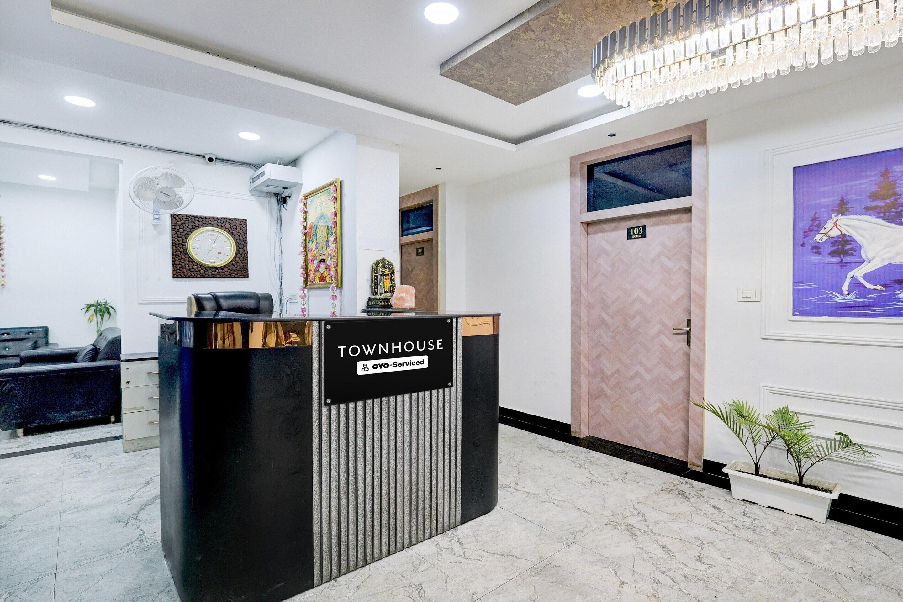 A reception desk labeled 'TOWNHOUSE' with a sign indicating 'OYO-Serviced.'