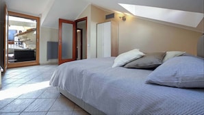 Una camera da letto con un letto, una porta e vista su un balcone.