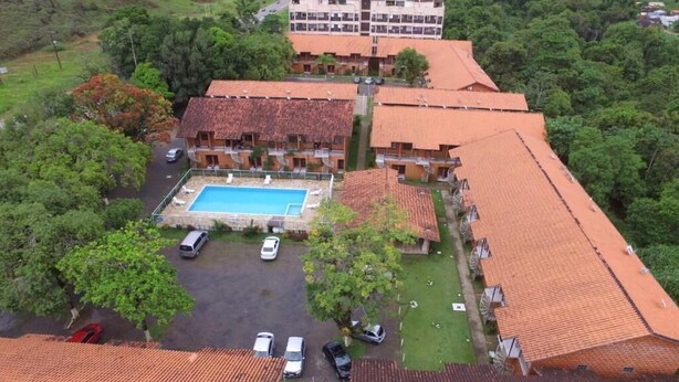 Eine Vogelperspektive auf ein Hotel mit Schwimmbad, mehreren Gebäuden und umgebender Bepflanzung.