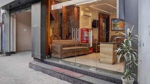 A modern hotel entrance with a glass facade, a seating area, and a reception desk. - Deluxe With Twin Bedram Talai Crossway (Amritsar)