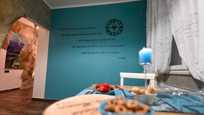 Et værelse med en turkis væg, et ur, et stearinlys og et bord med mad.