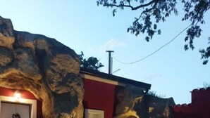 Et hus med en facade af sten, en røddør og et lille vindue.
