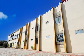 A hotel building with a modern facade, multiple windows, and a clear sky. - Deluxe Renigunta Near Railway Station (Renigunta)