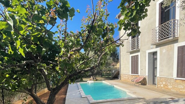 Un mur de pierre, une piscine et un bâtiment doté de balcons.
