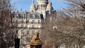 Un edificio histórico con múltiples cúpulas y una cúpula central, rodeado de árboles y un parque.