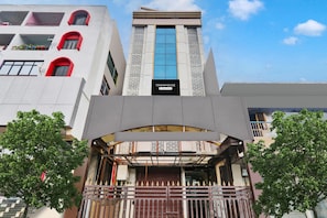 A modern building with a prominent 'TOWNHOUSE' sign, a central glass facade, and a gated entrance.