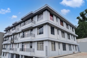 A multi-story hotel with balconies, large windows, and a sign indicating it is a hotel.