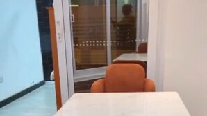 Un comedor con una mesa blanca y sillas naranjas.