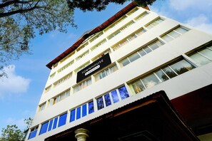 A multi-story building with a sign reading 'TOY HOUSE' and a red roof. - Super Deluxe Room The Olive Star (Mysore)