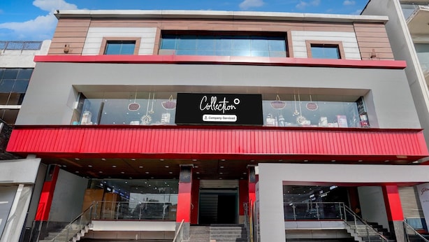Ein modernes Gebäude mit roter und weißer Fassade, einem gut sichtbaren 'Collection'-Schild und einer Treppe, die zum Eingang führt.
