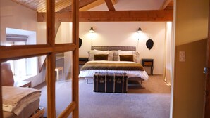 A bedroom with a wooden ceiling, a bed with multiple pillows, a nightstand, and a suitcase on the floor. - Clos de Miribel-renovated former wine storehouse in the heart of Givry, quiet location for 15 people (Givry)