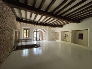 Ein großzügiger Innenraum mit Steinwand, Holzbalken und einem Balkon.