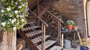 A rustic stone staircase with wooden railings, a wooden handrail, and a flower pot on the landing. - Clos de Miribel-renovated former wine storehouse in the heart of Givry, quiet location for 15 people (Givry)
