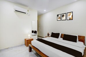 Ein Schlafzimmer mit Bett, Nachttisch, Lampe, Klimaanlage und Wandbild.