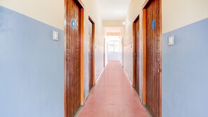 A hallway with wooden doors, a red carpet, and a blue and white wall. - Saver Double Last Gate Near Dispur Law College (Guwahati)