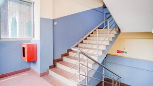 A staircase with metal railings, a red fire alarm box, and a blue wall. - Saver Double Last Gate Near Dispur Law College (Guwahati)