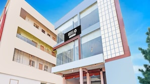 A modern hotel building with a prominent 'HOTEL' sign, multiple floors, and large windows.
