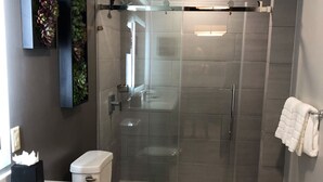 A modern bathroom with a glass-enclosed shower, a white toilet, and a marble countertop. - Saint Martin Dawn Beach Club 2027 (SINT MARTEEN)