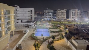 Ein mehrstöckiges Gebäude mit Balkonen, einem Dachpool und einer angelegten Gartenanlage.