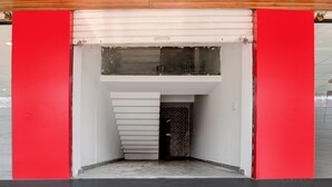 Interior moderno com escadaria central, parede estampada e teto com iluminação embutida.