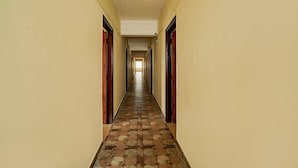 A long, narrow hallway with a patterned floor and doors on either side. - Deluxeurban Drift (Bengaluru)
