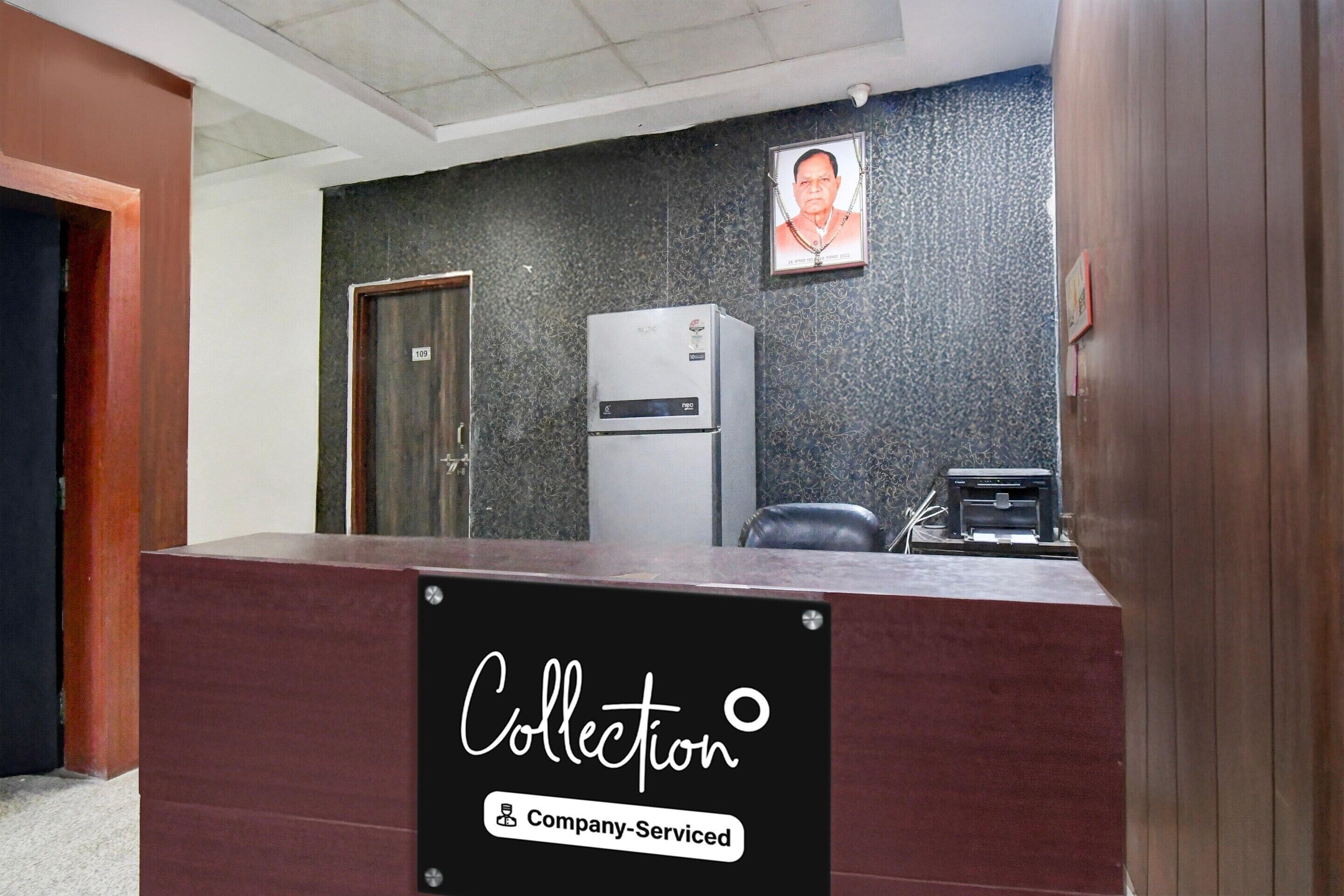 A reception desk with a sign reading 'Collection & Company-Serviced.'