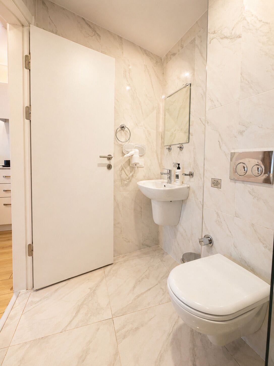 A modern bathroom with a toilet, sink, and mirror.