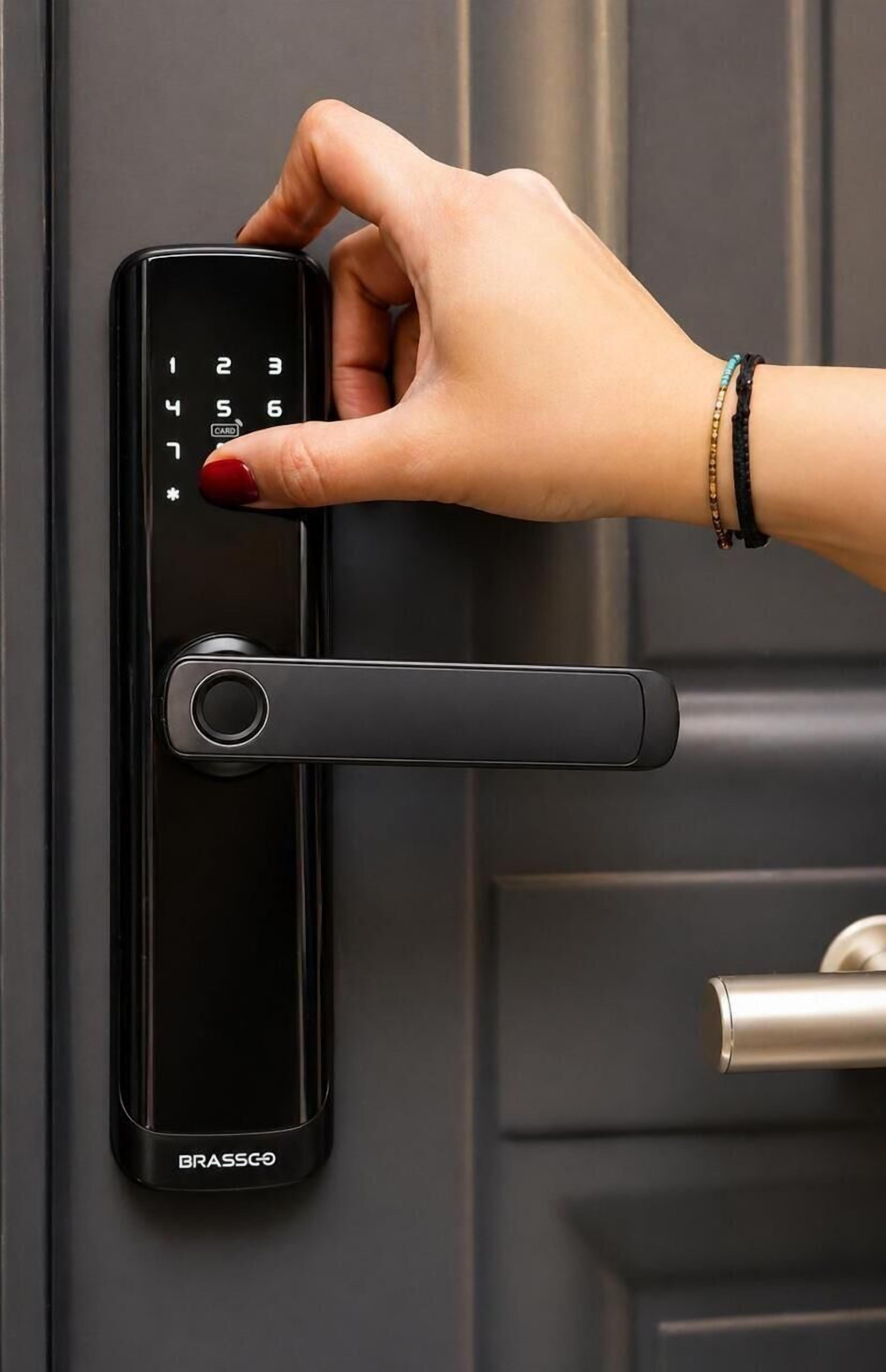 Una mano usando una cerradura digital en una puerta.