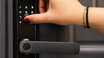 A hand using a digital lock on a door.