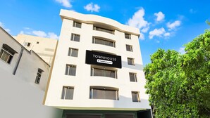 A multi-story building with a sign reading 'TOWNHOUSE Company Serviced.' - Super Deluxe Roomred Hills Sitara Grand (Hyderabad)