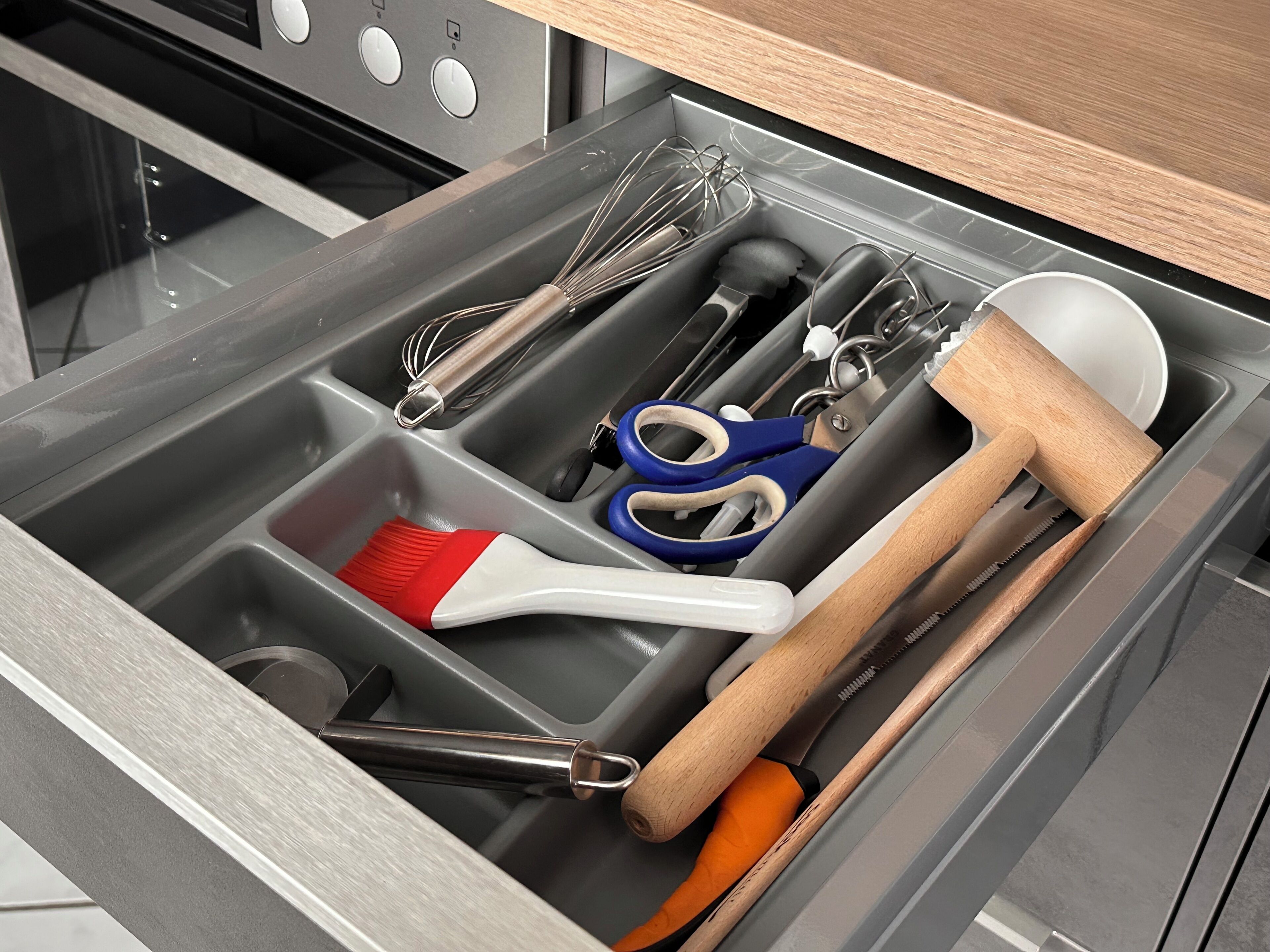 Un cajón de cocina con utensilios y herramientas.