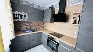 Een magnetron, een oven, een kookplaat, een vaatwasser