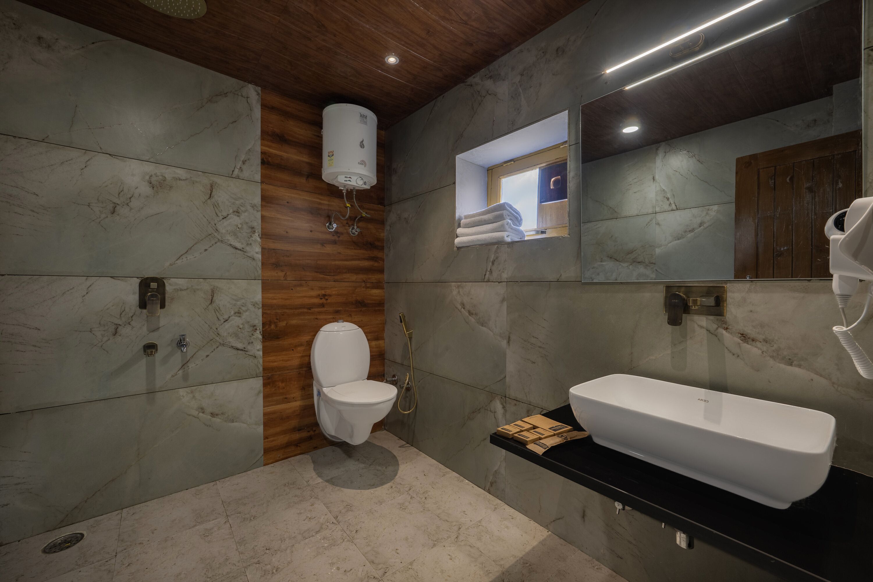 A modern bathroom with a toilet, bidet, and a large white sink.