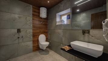 A modern bathroom with a toilet, bidet, and a large white sink.