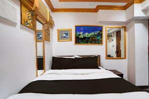 A hotel room with a bed, a night sky painting, a framed picture, and a mirror. - Collection O Bangalore East Railway (Bengaluru)