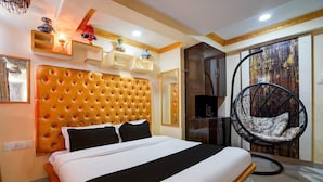 Ein Hotelzimmer mit einer gepolsterten Kopfteil, einem Hängekorbsessel und einem Bett mit weißer und schwarzer Bettwäsche.
