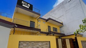 A hotel with a 'HOTEL' sign, a gated entrance, and a balcony with barbed wire. - Deluxesamne Ghat (Varanasi)