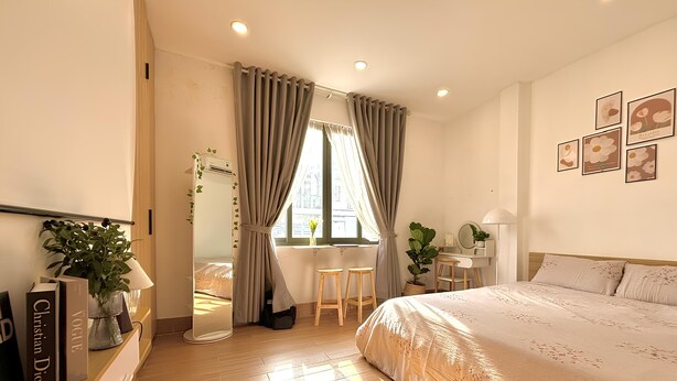 A bedroom with a bed, a desk, a chair, and a window with curtains. - Sam House (Ho Chi Minh City)