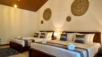 A hotel room with two beds, a wooden ceiling, and decorative wall art.