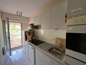 Una cocina moderna con lavavajillas integrado, un lavaplatos, un tostador y un refrigerador.