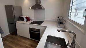 A compact kitchen with a microwave, toaster, dishwasher, and a window with blinds. - Renovated house near the beach - 8 guests (Roses)