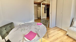 Ein Essbereich mit einem runden Tisch, Stühlen und einer Couch.