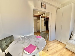 A dining area with a round table, chairs, and a sofa. - Central studio, AC - 2 guests (Ajaccio)