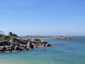 A coastal landscape with rocky terrain and clear blue waters. - Apartment exceptional sea view - 3 guests (Trégastel)