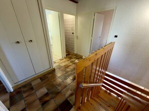 Eine Treppe mit hölzernem Geländer und einem Schachbrettmuster auf dem Boden.