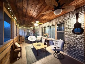 A cozy interior with wooden beams, a stone wall, and a seating area with a table and chairs. - The Whole Zen Lodge: Main House+2 Private Hot Tubs (Lawton)