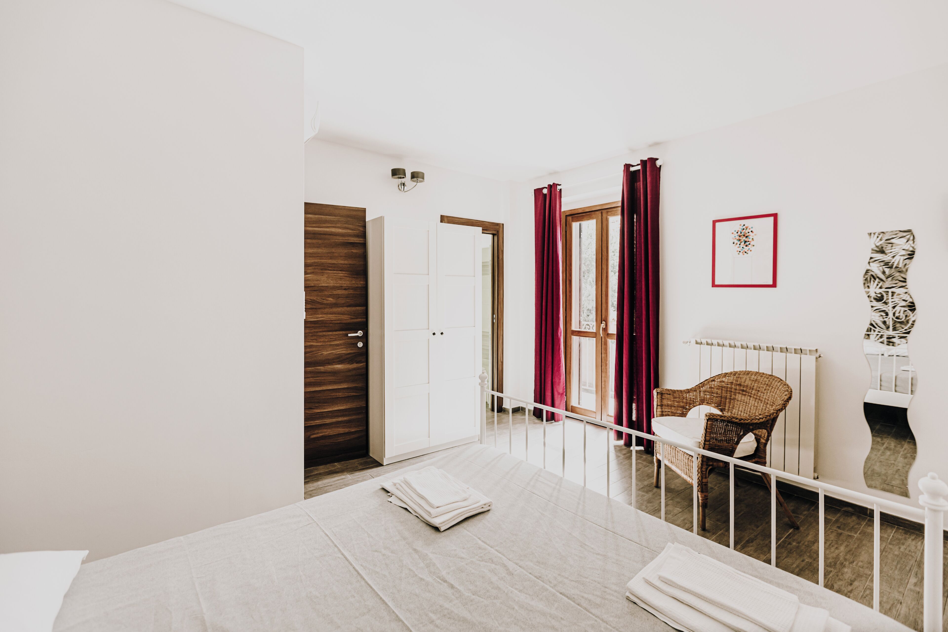 Un dormitorio con una cama, una silla, un radiador y una puerta.