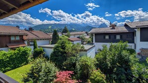 Zona residencial com casas, um jardim e montanhas ao fundo.