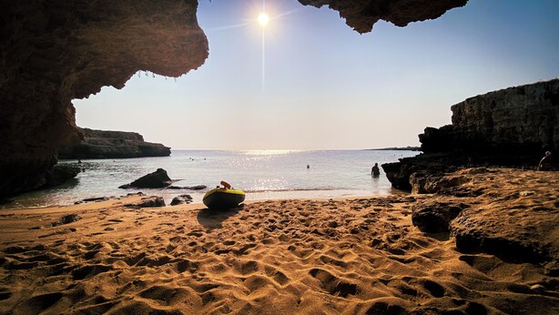 A beach with clear water, a boat on the sand, and rocky cliffs. - Luxury private condo for 2 w/pool in Apulian hills. Only 15 mins from beach! (Puglia)